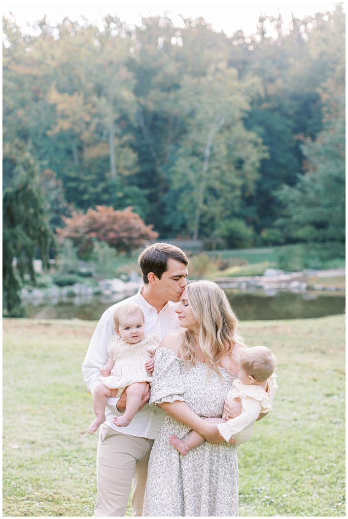 Father Kisses Mother's Head While Holding Their Twin Babies