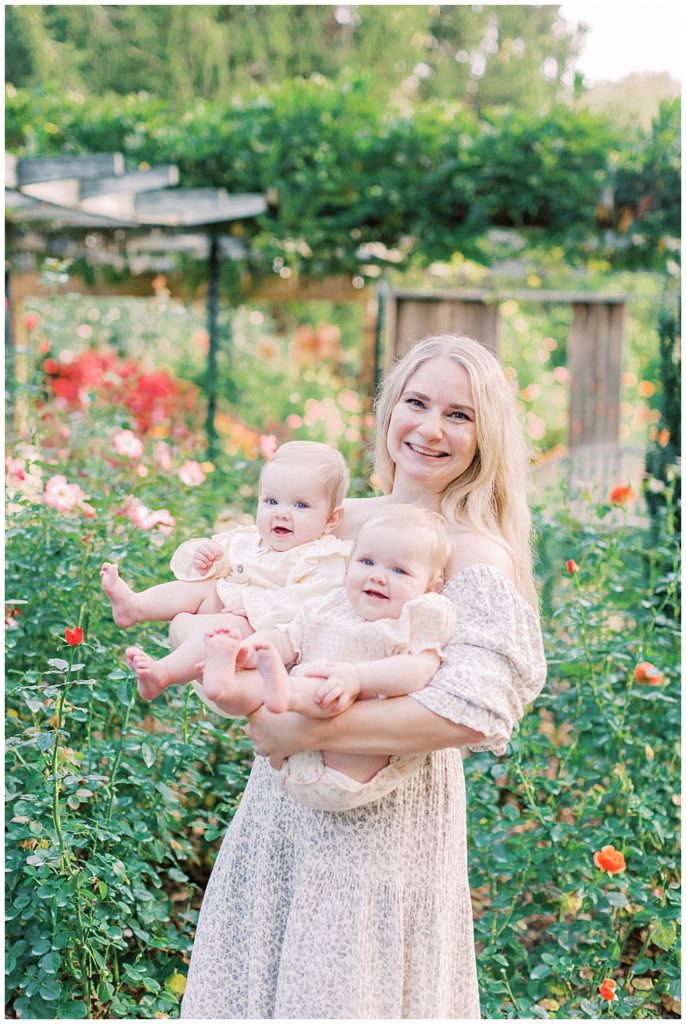 Mother Holds Her Twin Babies And Smiles