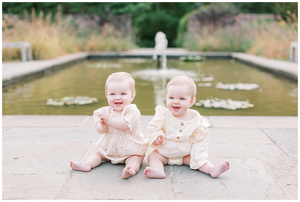 Twin Girls Sitting Up By A Pond At Brookside Gardens