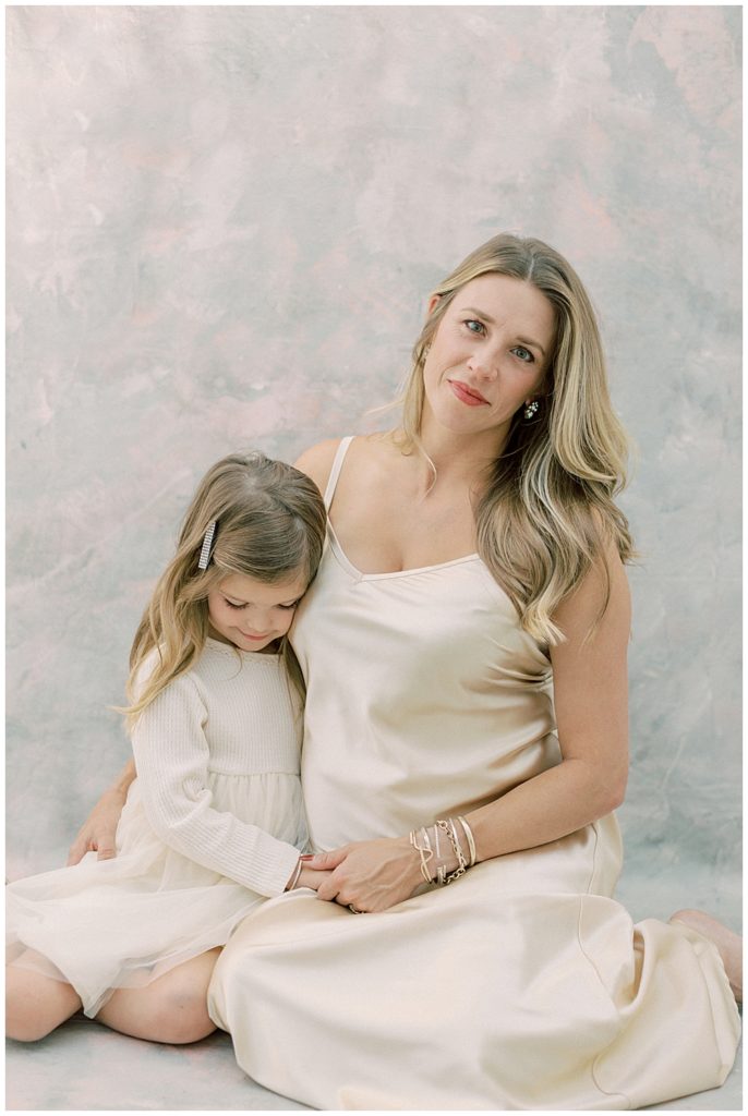 Mother And Daughter Embrace While Mother Smiles