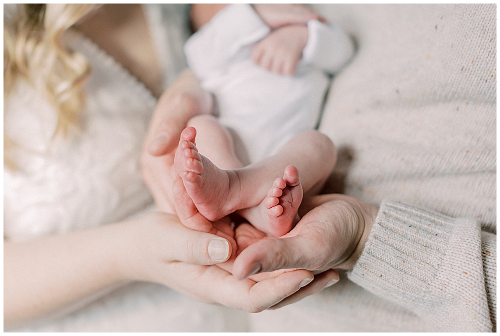 A Mother And Father Cup Their Newborn's Feet