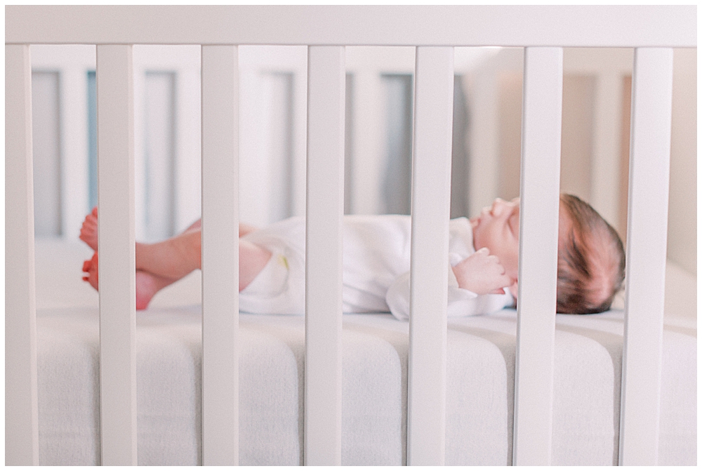 A Newborn Baby Lays In Her White Crib In Arlington Va During Her Newborn Session