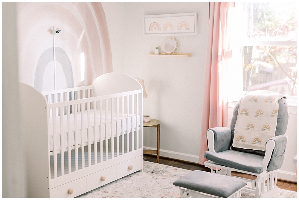 A White Nursery With A Rainbow On The Wall