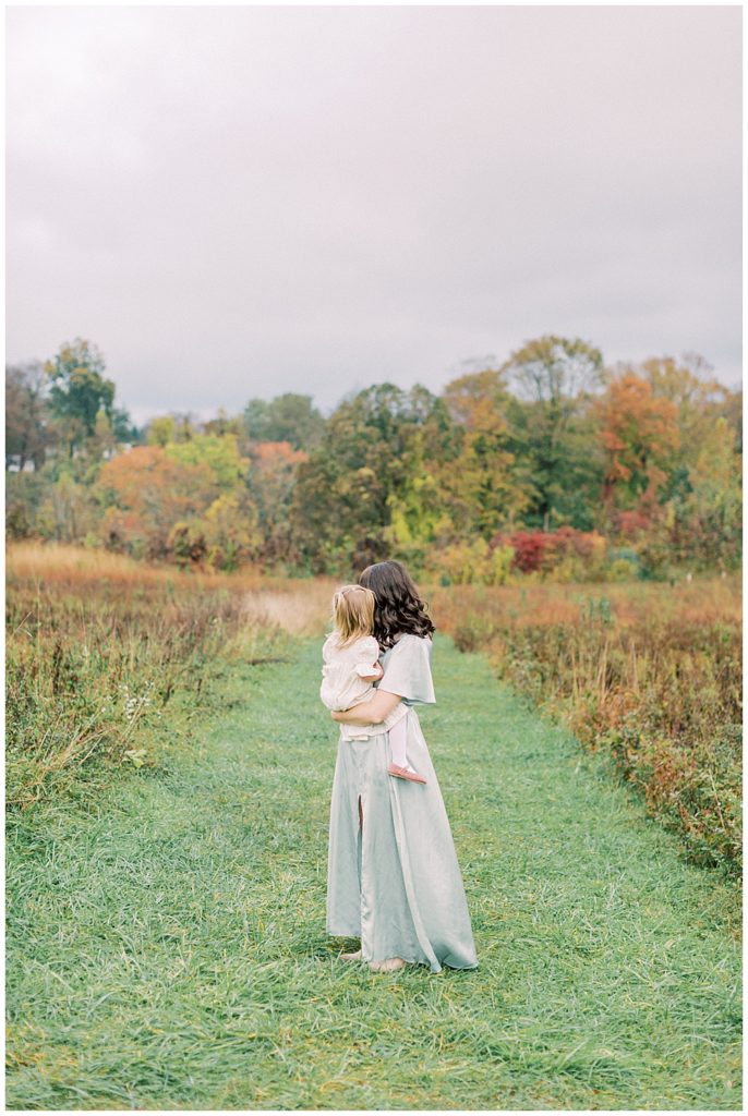 Mother And Daughter Cuddle Together While Standing In A Pathway At The Howard County Conservancy