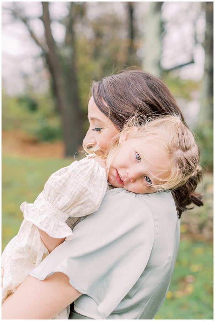 Little Girl Rests Her Head On Her Mother's Shoulder