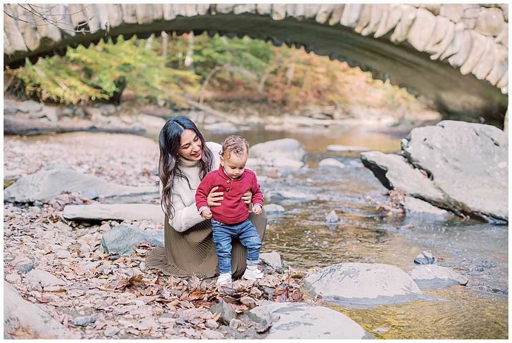 A Mother Crouches Down To The Ground With Her Son At Rock Creek Park In Dc