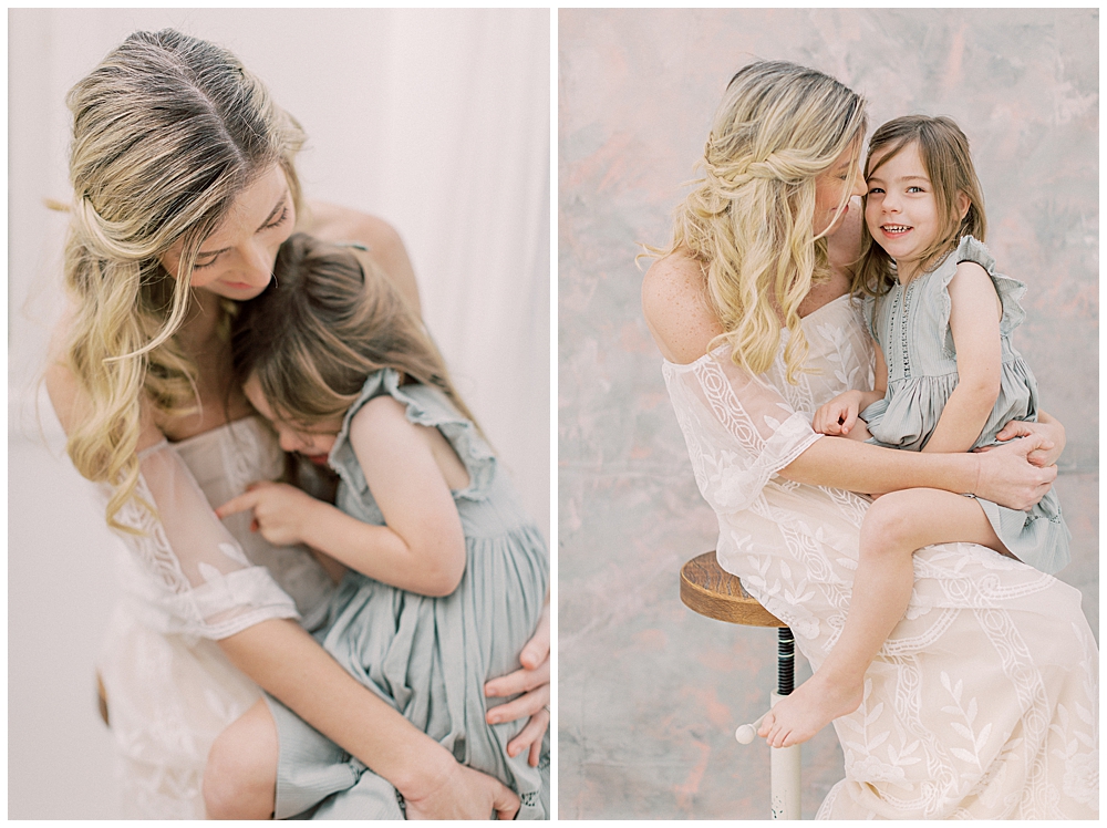 Little Girl In Green Noralee Dress Sits On Her Mother's Lap During Their Studio Motherhood Session