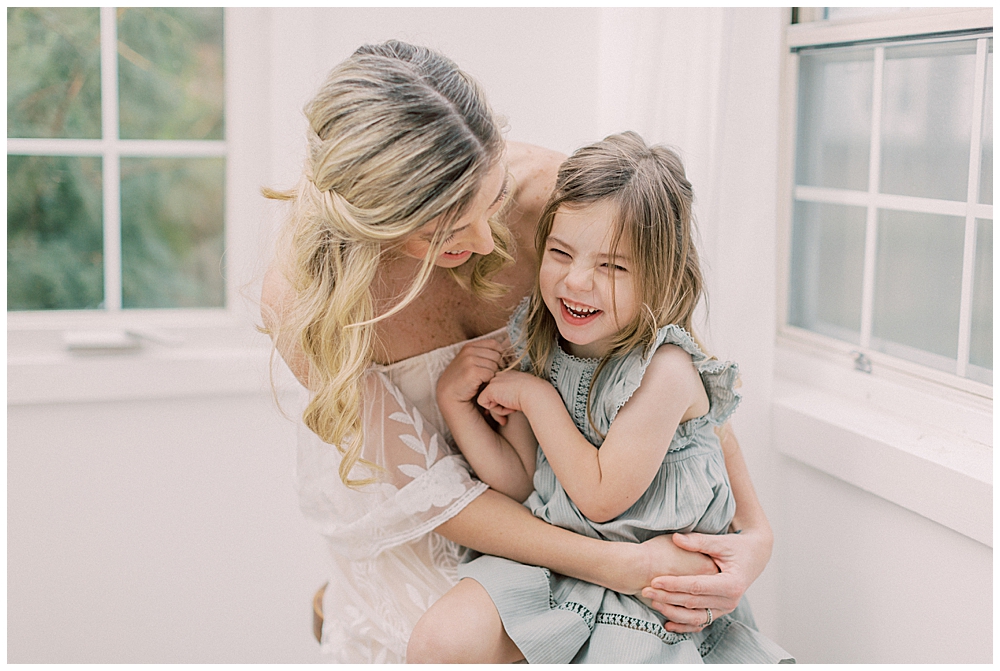 A Little Girl In A Green Dress Sits On Her Mother's Lap And Laughs During Her Photo Session With Dc Family Photographer Marie Elizabeth Photography