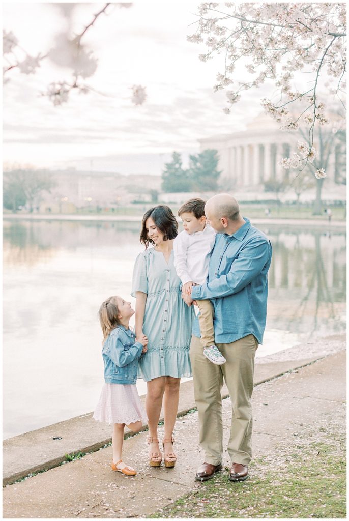 Family Looks At Their Children As They Stand Near The Cherry Blossoms At The Tidal Basin