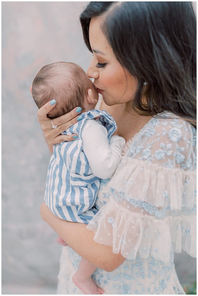 A Mother Kisses Her Infant Son During Her Motherhood Studio Session