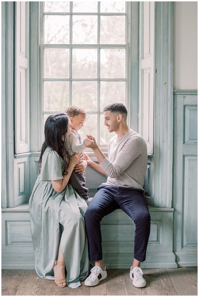 Parents sit in window at Salubria with their toddler son