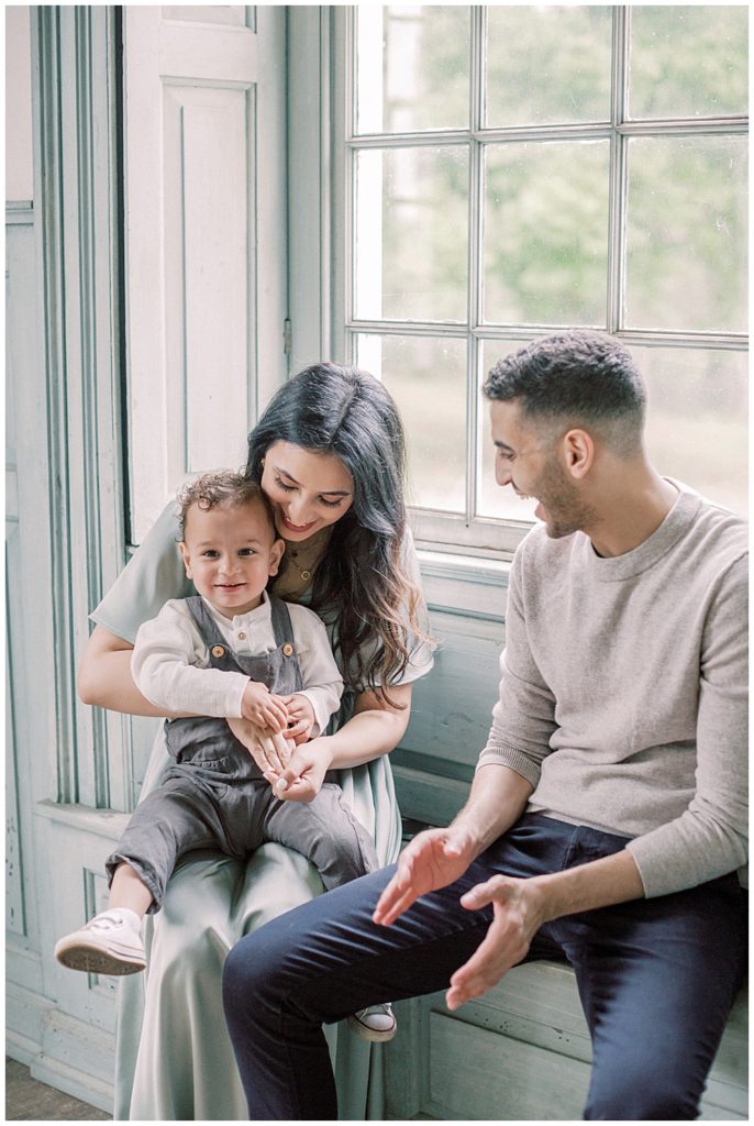 Elegant Family Photos at Salubria with mother, father, and toddler sitting in the window