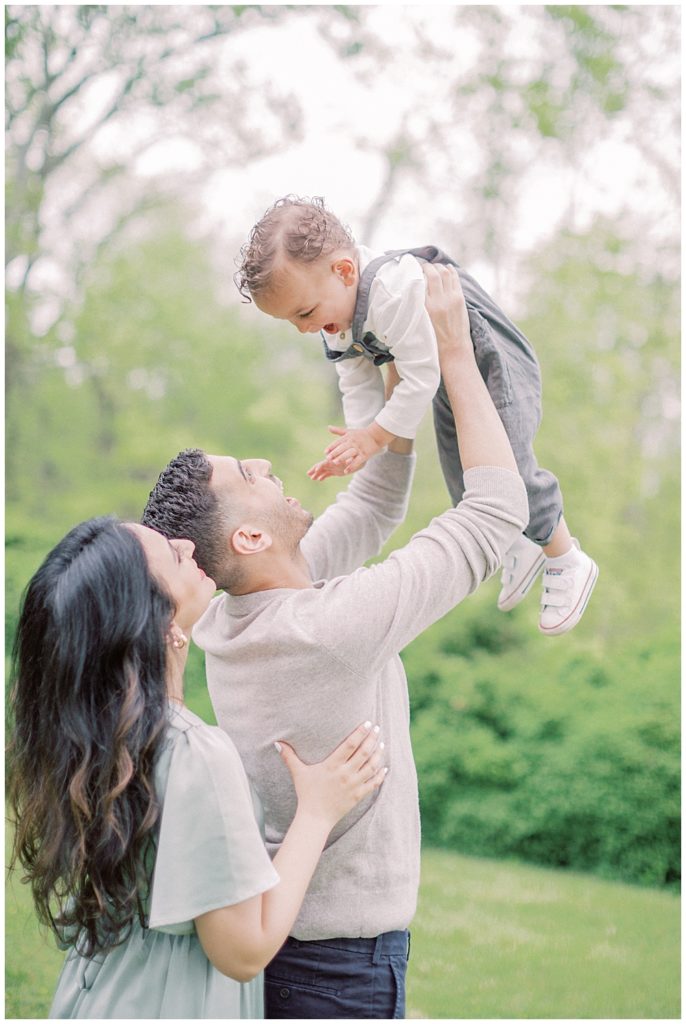 Little Boy Held Up In The Air By His Parents