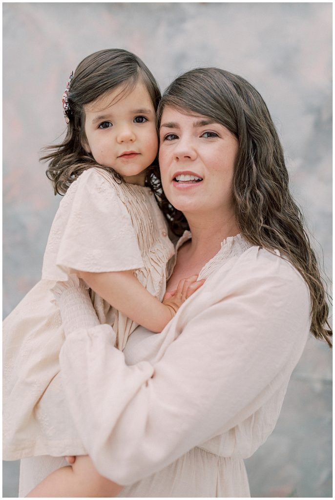 Mother Holds Up Her Daughter To Her Face While They Both Smile