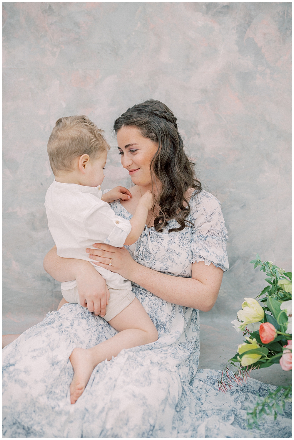 Mother Smiles At Her Son While Holding Him