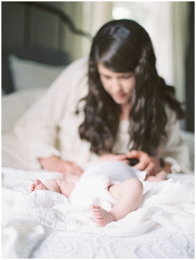 A Mother Lays On The Bed With Her Newborn Daughter