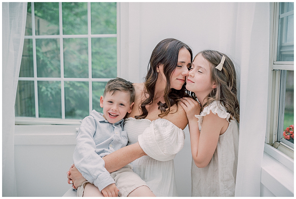 A Brown Haired Mother Sits On A Stool Nose Nuzzling Her Daughter