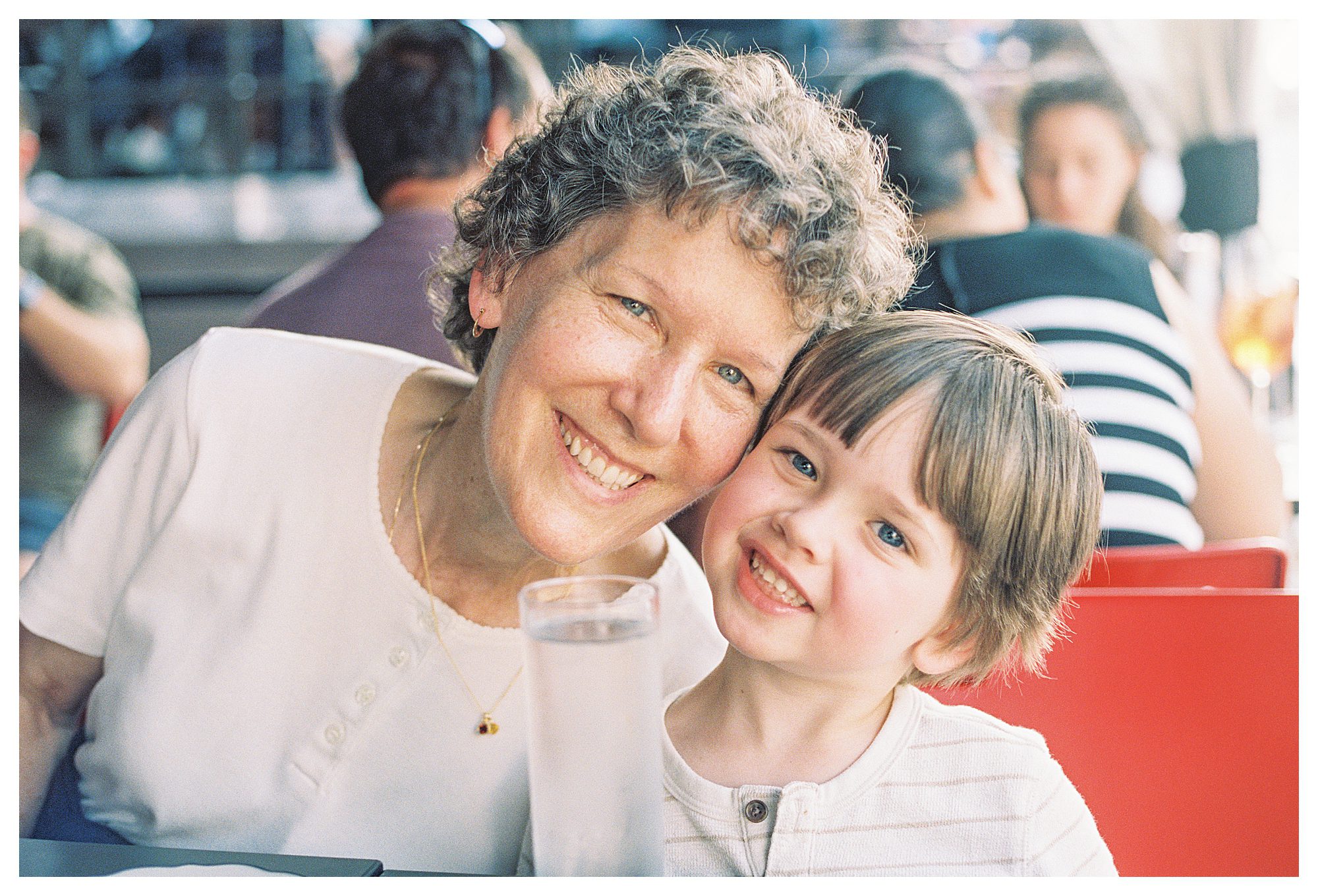 Grandmother Leans Down And Smiles With Her Grandson.