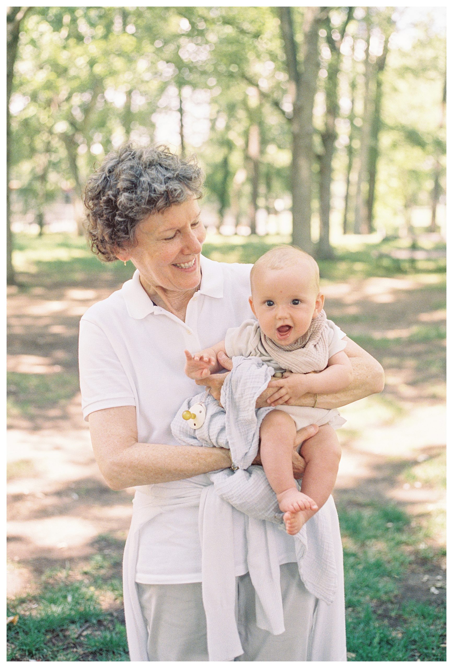 Grandmother Holds And Smiles At Her Infant Granddaughter.