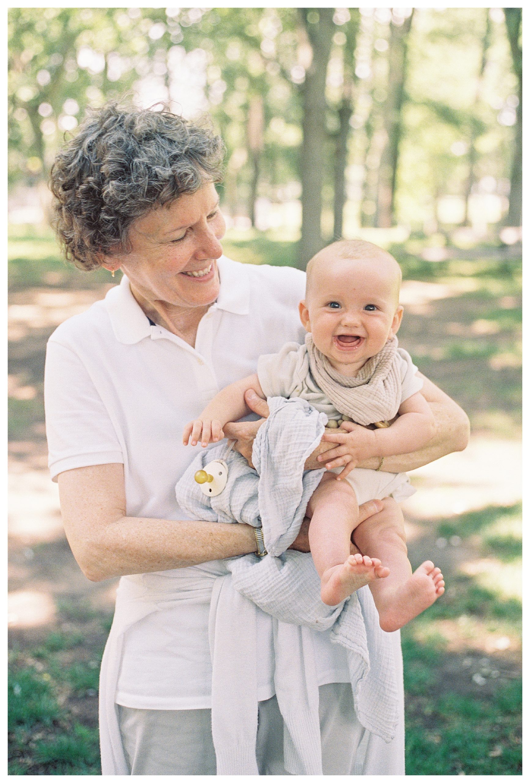 Baby Girl Smiles As She Is Held By Her Grandmother