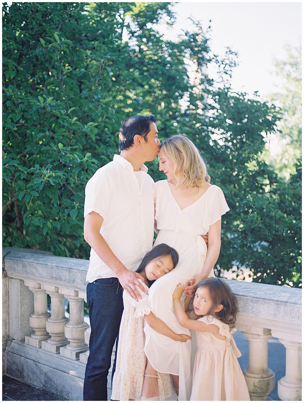 Father Kisses His Wife's Forehead As She Sits On The Ledge At Dar Constitution Hall With Her Family.