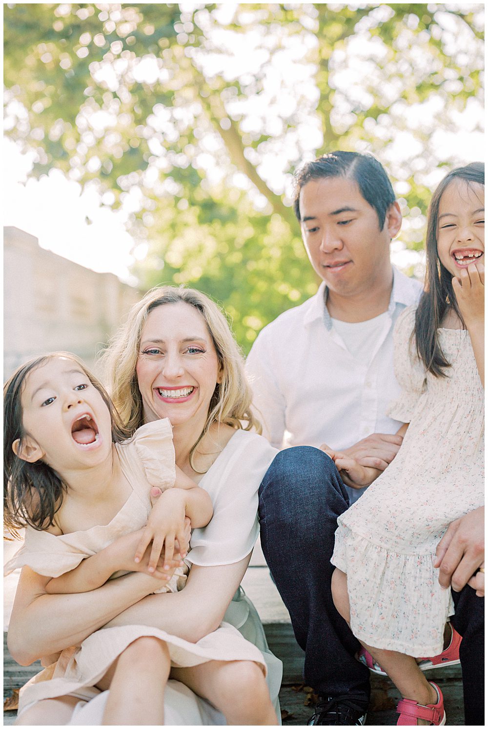 Family Of Four Sit On Steps Of Dar Constitution Hall And Laugh During Their Dar Constitution Hall Family Photo Session.