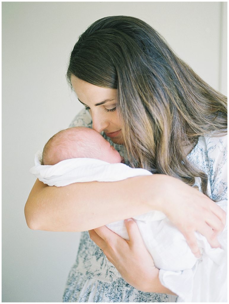 Mother Brings Her Newborn Baby Up To Nuzzle His Forehead During Their Joint Base Andrews Newborn Session.