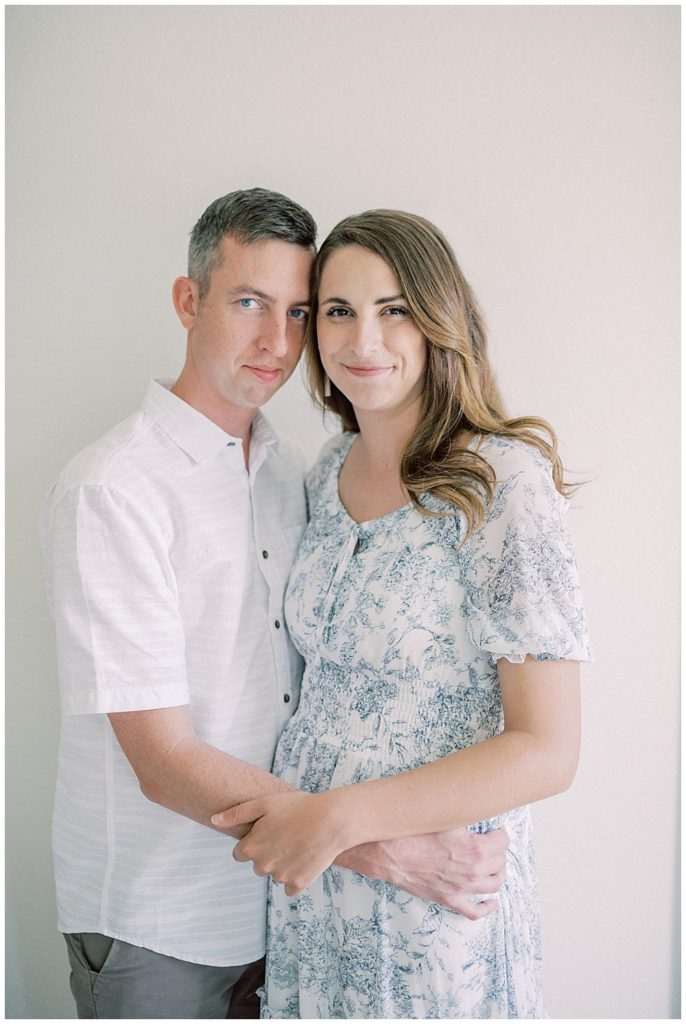 Brown Hair Woman And Man Hold One Another And Smile At The Camera.