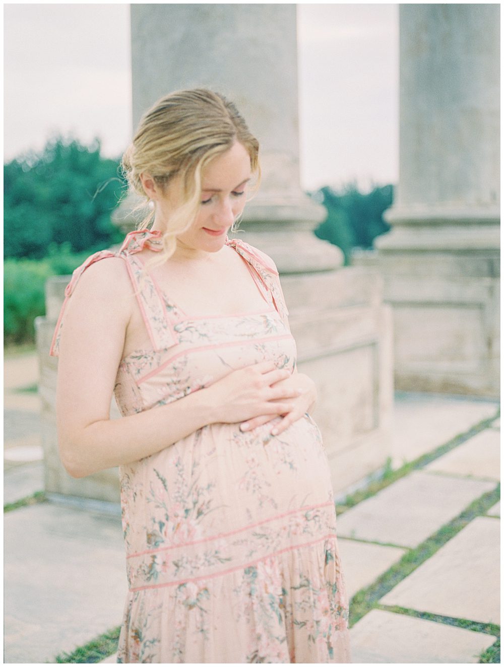 Pregnant Mother Places Her Hands On Top Of Her Belly During Her Maternity Session At The National Arboretum.