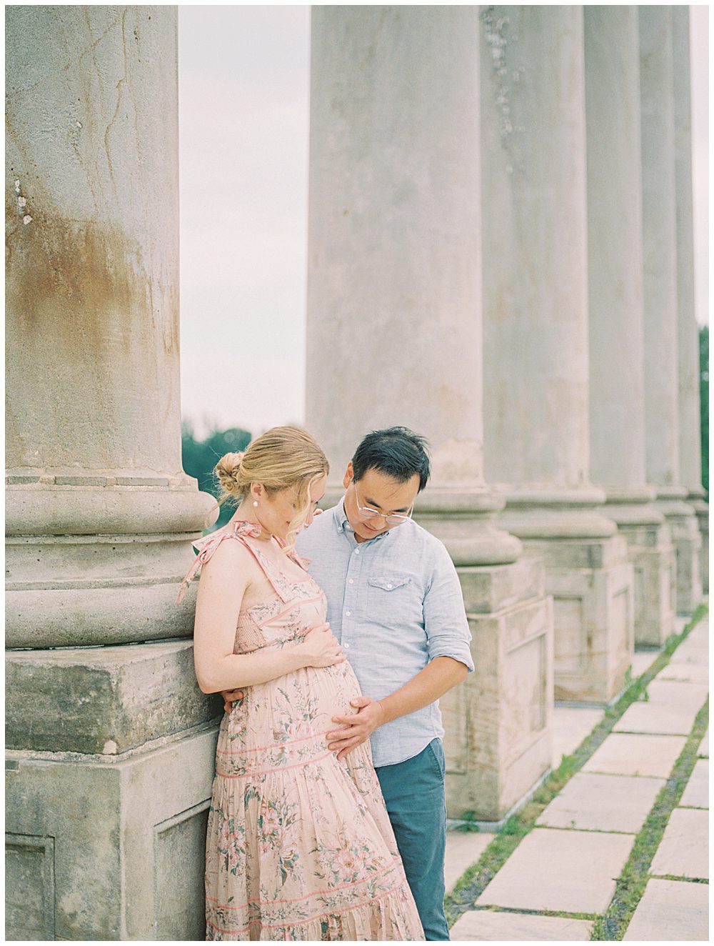 Expecting Parents Lean Against Columns During Their National Arboretum Maternity Session.