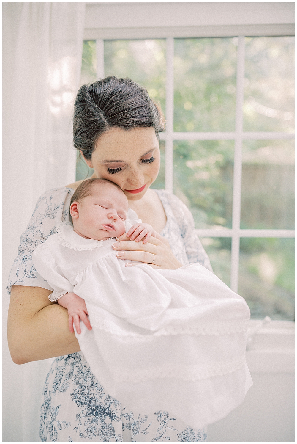 New Mom Holds Her Newborn Baby Up To Her Cheek