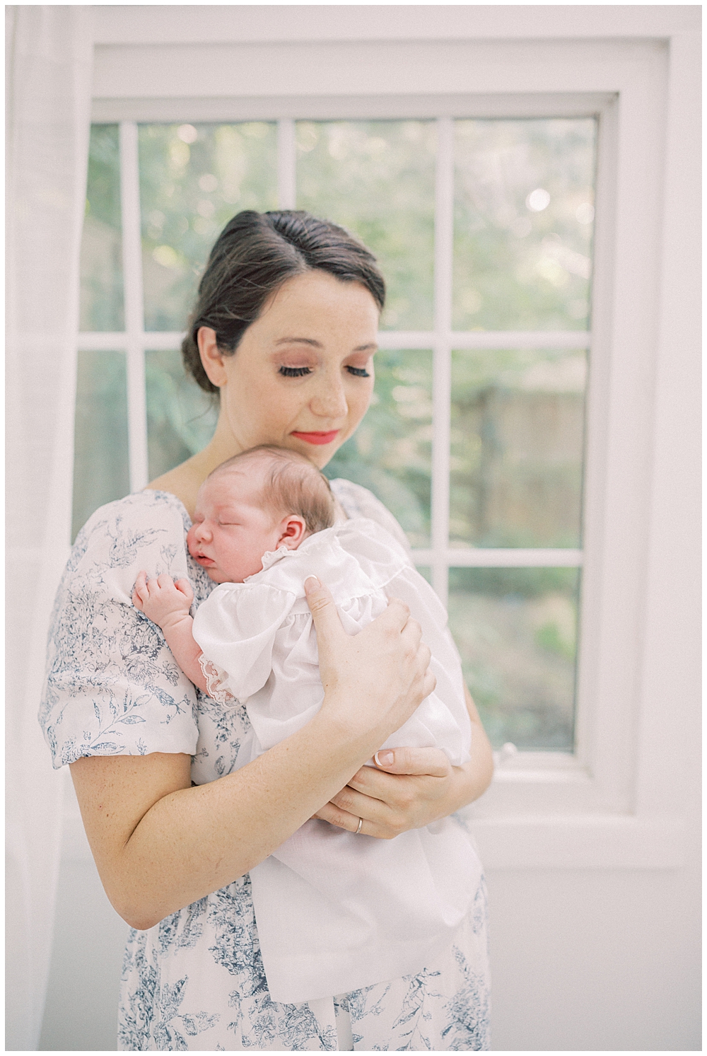 Mother Closes Her Eyes While Holding Her Newborn Daughter Up To Her Chest