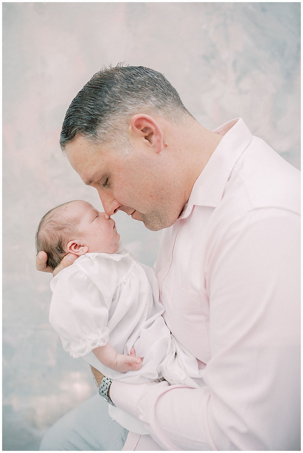 Father Holds His Newborn Daughter Up To Nuzzle Her On The Nose