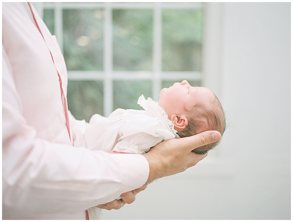 View Of Newborn Baby's Profile While Held By Her Father