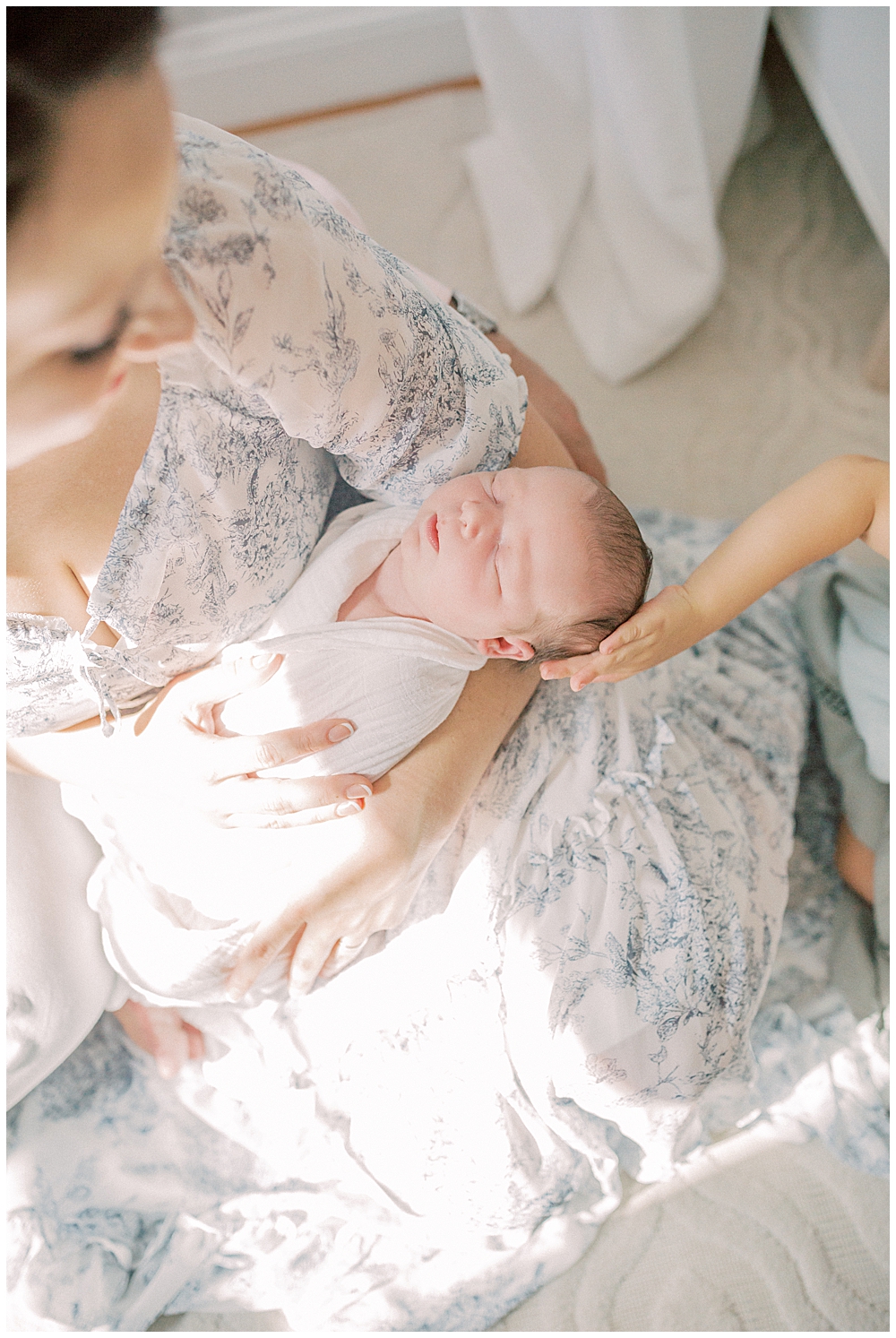 Newborn Baby Held By Her Mother Gets A Head Pat From Her Big Sister