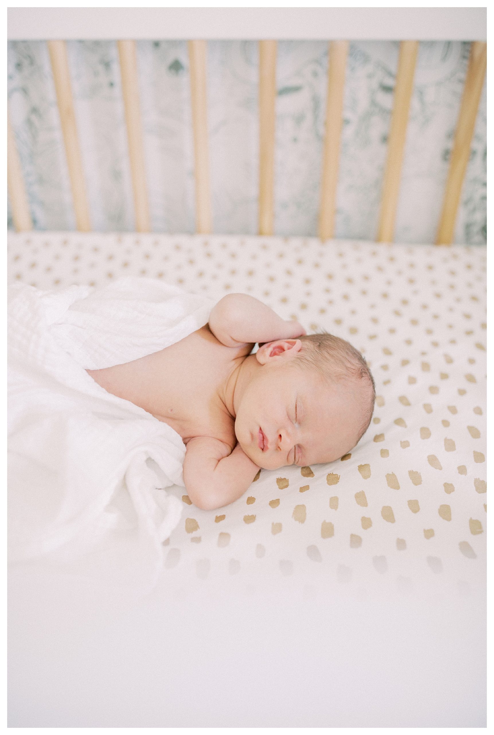 Newborn Baby Lays In Crib With Hands Behind His Head During Dc Newborn Session.