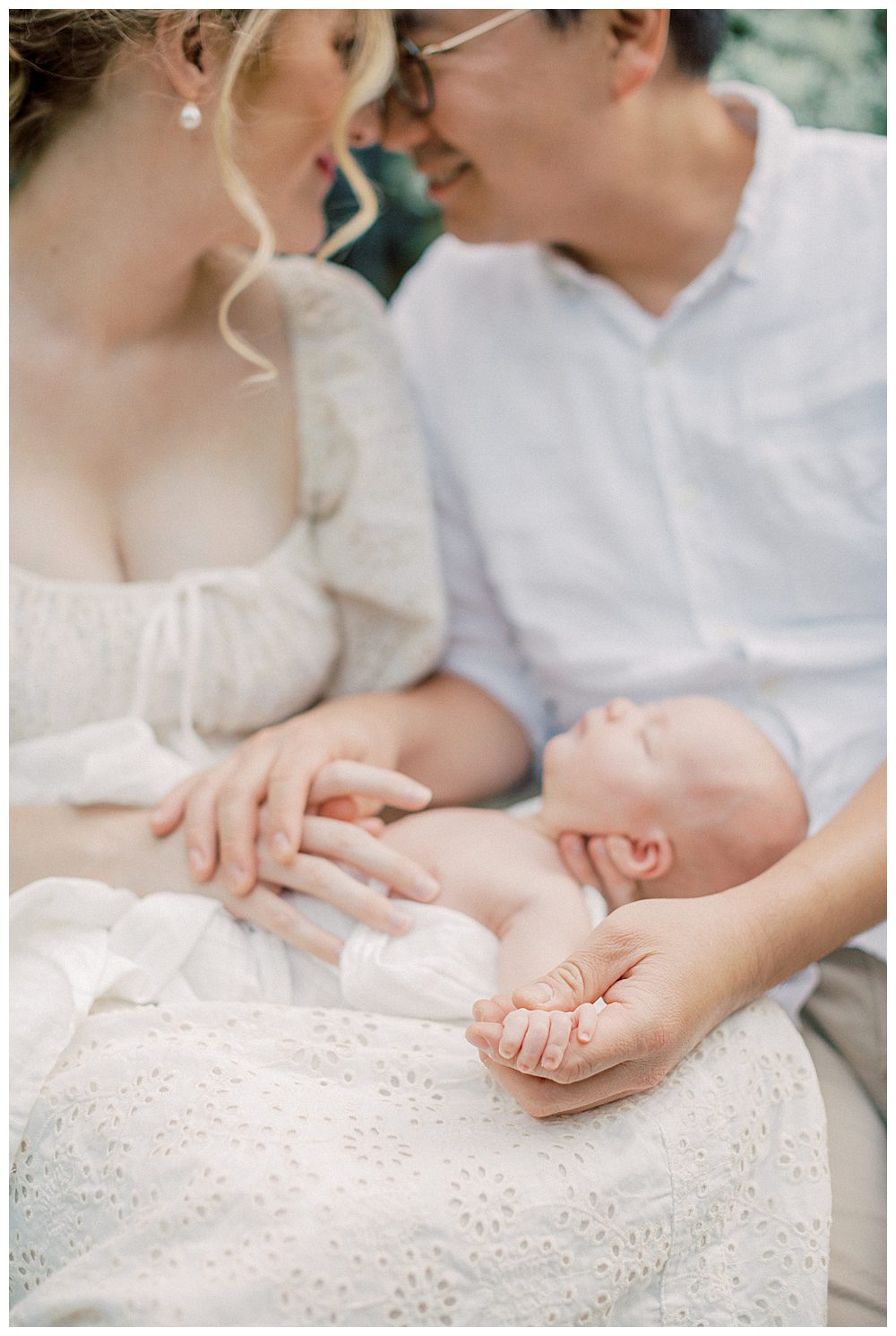 Newborn Baby's Fingers Wrap Around Father's Hand While Being Held By Parents During Alexandria Va Newborn Session.