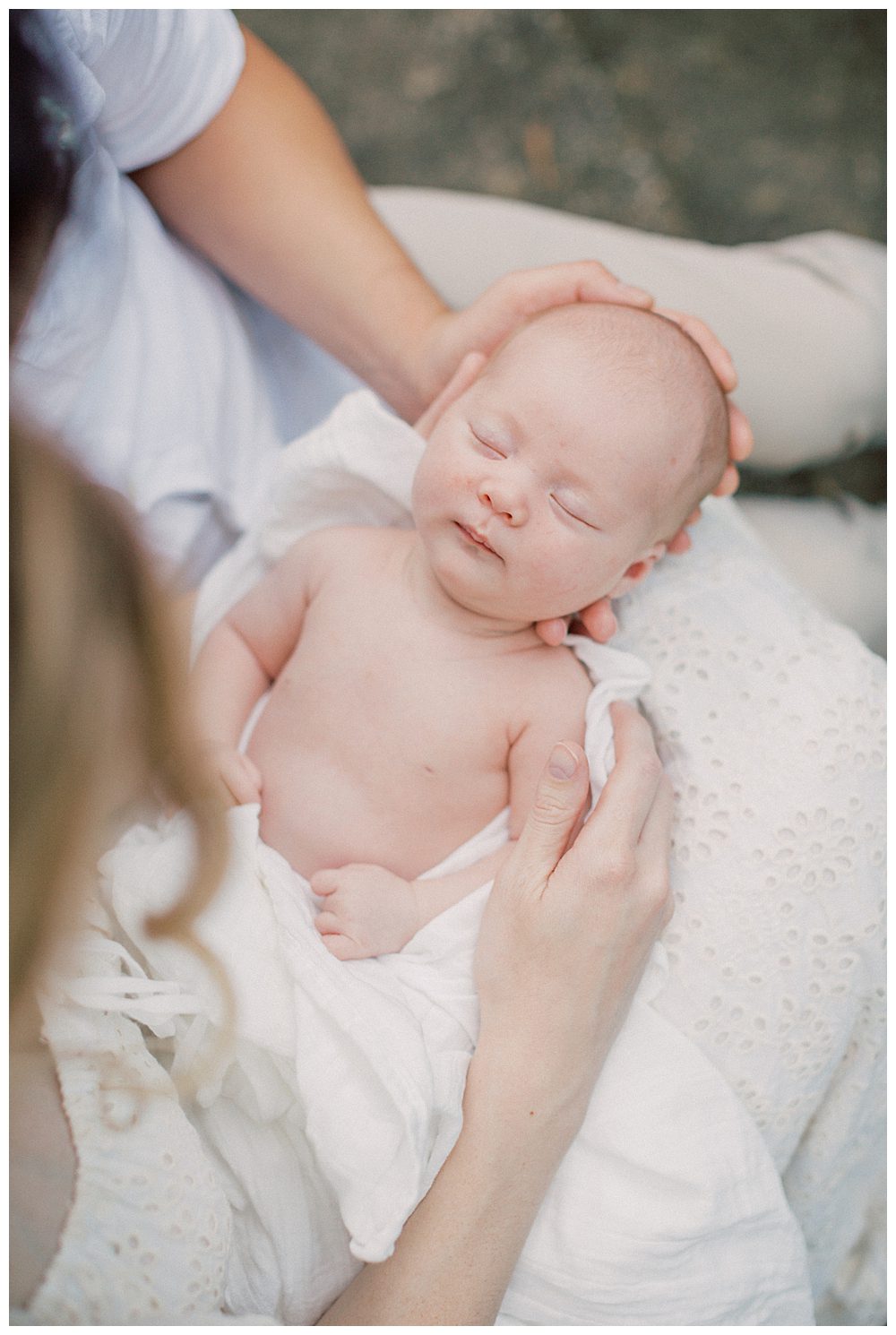 Newborn Baby Held On Mother's Lap Held By Mother And Father.