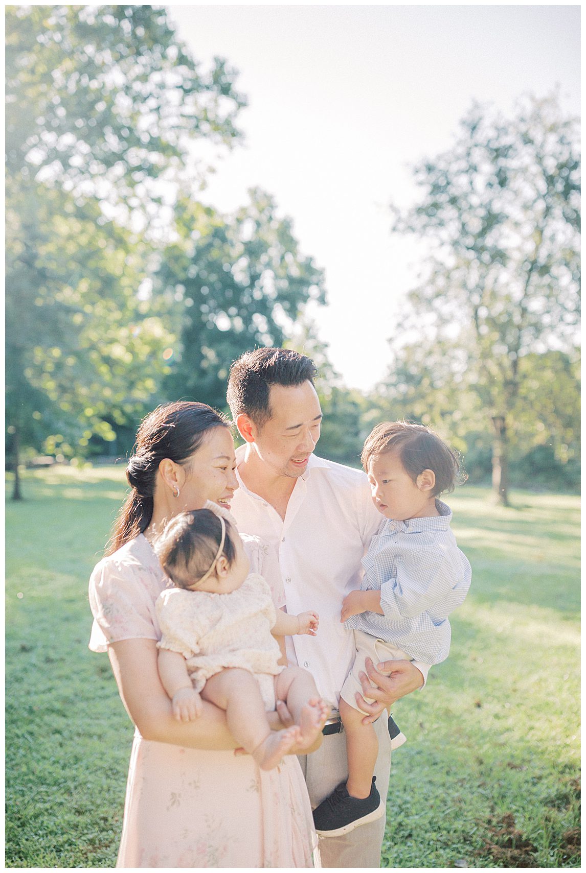 Mother And Father Stand Together, Holding Their Children At Colvin Run Mill.