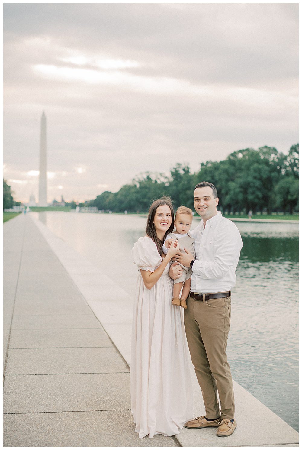 Parents Hold Toddler Son By Dc Reflection Pool During Dc Monuments Family Photo Session.