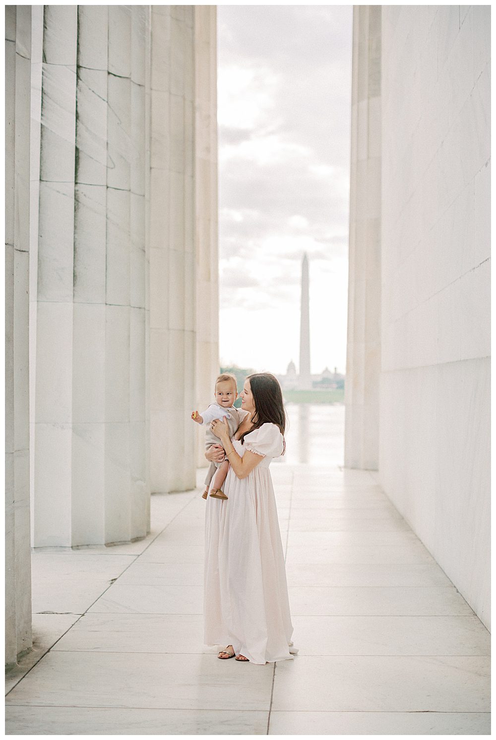 Mother Holds Her Toddler Son While Standing In The Lincoln Memorial.