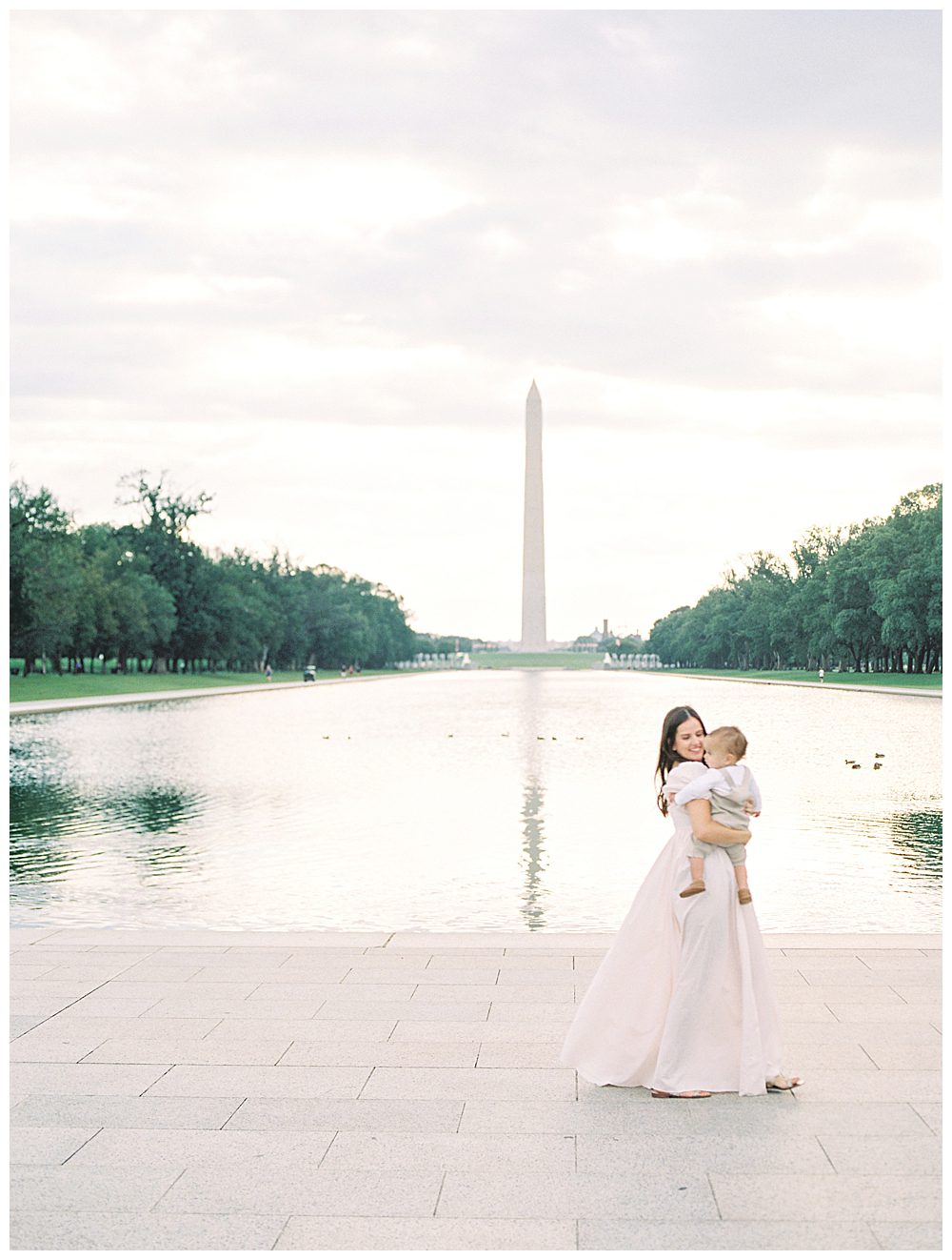 Mother Walks In Front Of The Washington Monument And Reflecting Pool During Dc Monuments Family Photo Session.