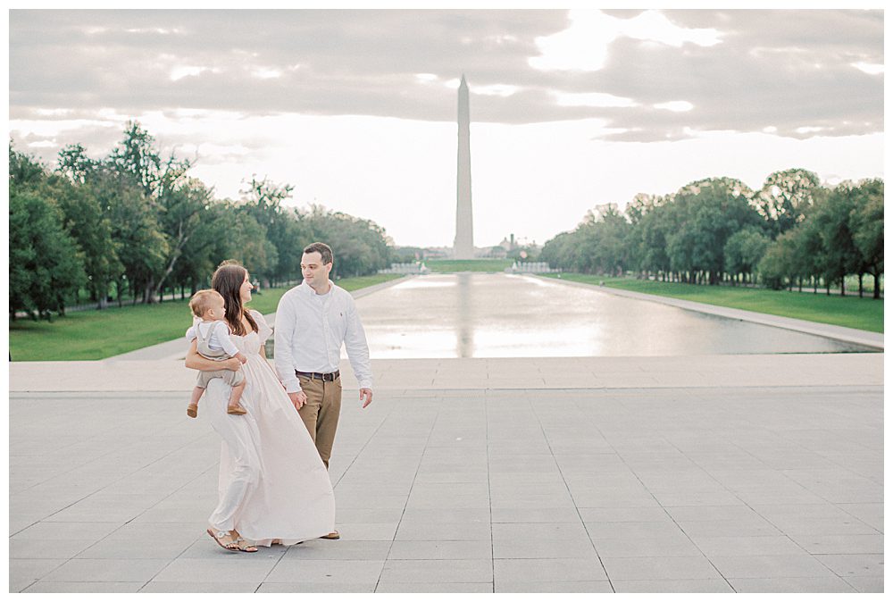 Mother And Father Walk In Front Of Washington Monument During Dc Monuments Family Photo Session