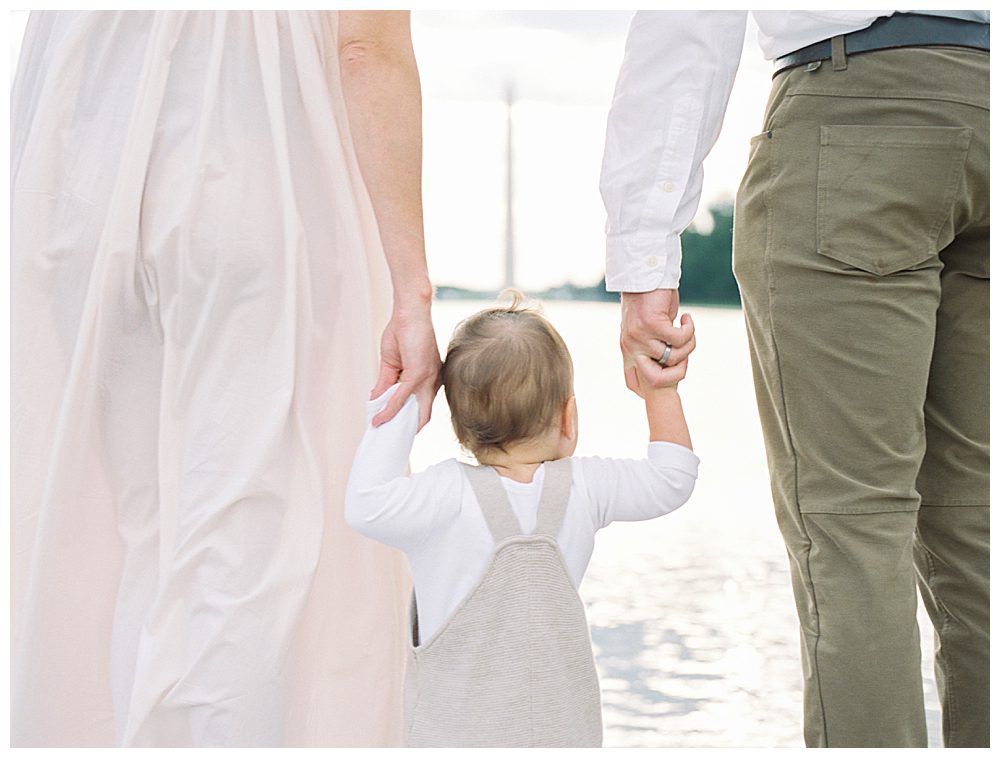 Little Boy Holds Parents' Hands While Standing In Front Of Washington Dc Reflecting Pool.