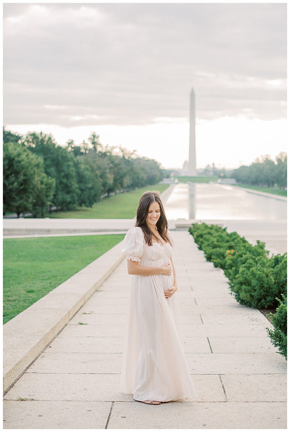 Pregnant Mother Holds Belly While Standing In Front Of Washington Monument.