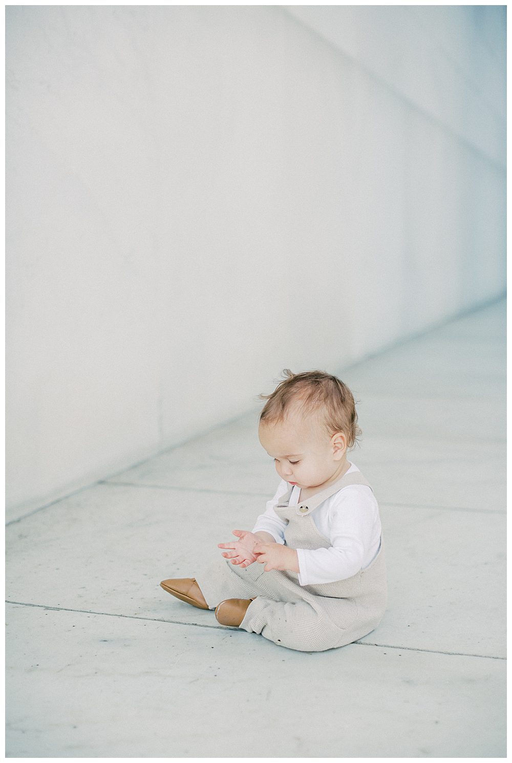 Toddler Boy Sits On Floor Of Lincoln Memorial.