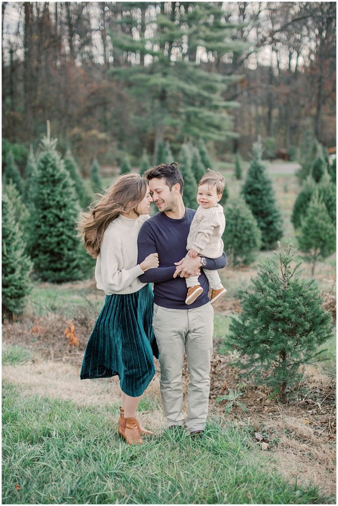 Mother And Father Face One Another As The Wind Blows During Christmas Card Photos.