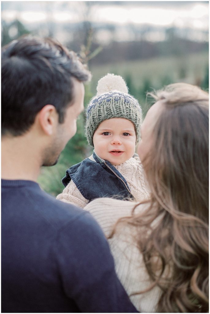 Little Boy Looks Over Parent's Shoulders.