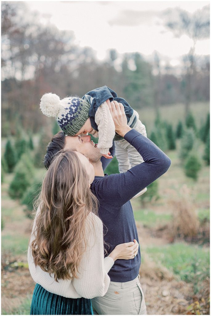 Parents Hold Up Son During Christmas Mini Sessions At Butler's Orchard.