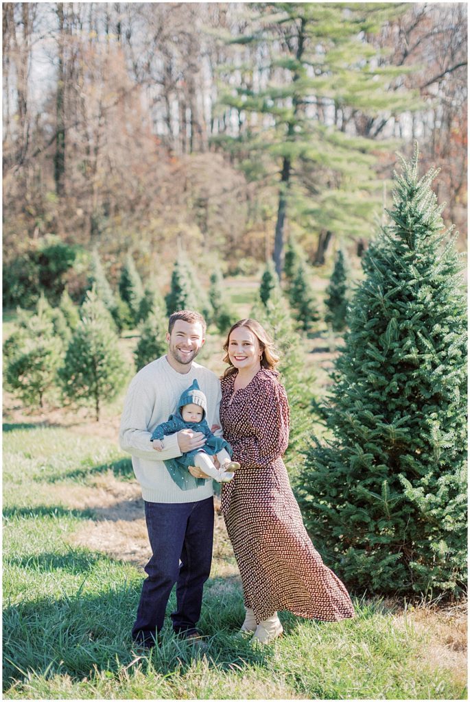 Family Stands And Smiles At Christmas Tree Farm.